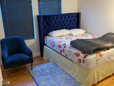 a bedroom with a bed and a blue chair at Exclusive Home in Newark