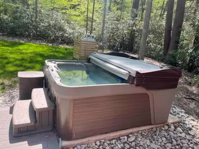 a hot tub with a slide in a backyard at Sullivan Trail Cottage in Tannersville