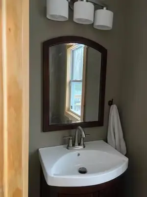 a bathroom with a sink and a mirror at Sullivan Trail Cottage in Tannersville