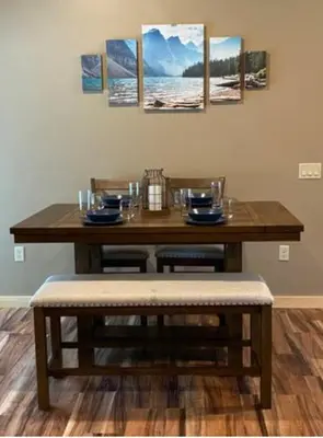 a dining room table with two chairs and a table with pictures on the wall at Sullivan Trail Cottage in Tannersville