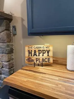 a sign that says the cabin is my happy place on a counter at Sullivan Trail Cottage in Tannersville