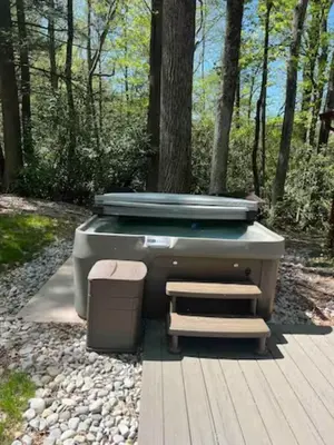 a hot tub and a trash can on a wooden deck at Sullivan Trail Cottage in Tannersville