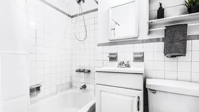 a white bathroom with a sink and a bath tub at Monthly Furnished 2BD in Hudson Yard, Manhattan, NYC! in New York