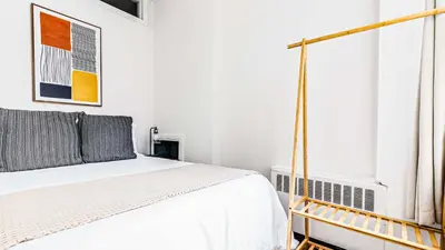 a white bedroom with a bed and a window at Monthly Furnished 2BD in Hudson Yard, Manhattan, NYC! in New York