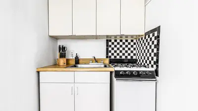 a kitchen with white cabinets and a sink at Monthly Furnished 2BD in Hudson Yard, Manhattan, NYC! in New York