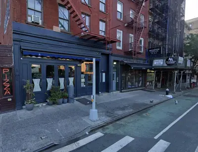 an empty street in a city with buildings at Chic West Village Studio on Bleecker Street in New York