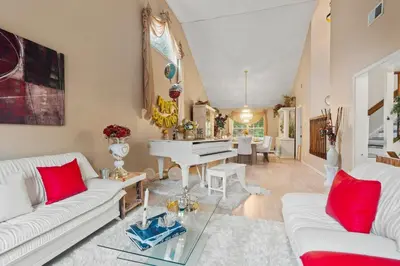 a living room with white couches and a piano at Ethereal Haven in West Milford