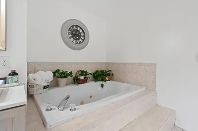 a white bath tub in a bathroom with a sink at Ethereal Haven in West Milford