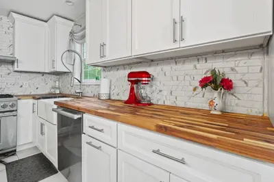 a kitchen with white cabinets and a red mixer on a counter at Ethereal Haven in West Milford