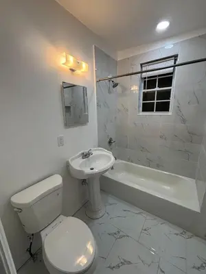 a white bathroom with a toilet and a sink at The loft 2 bedroom apartment in Newark