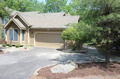 a house with a garage and a driveway at Cozy 4bd 4bath Grand Cabin Retreat in Camelback in Tannersville