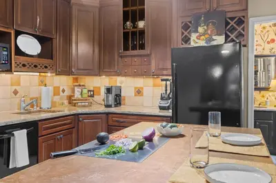 a kitchen with wooden cabinets and a black refrigerator at Riverfront Gem with Balcony, Patio and City Views in Harrisburg