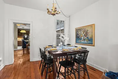 a dining room with a table with chairs and a painting at Riverfront Gem with Balcony, Patio and City Views in Harrisburg