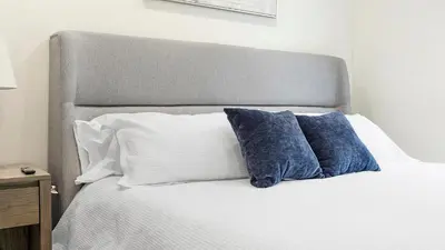 a bed with two blue pillows on top of it at Landing Modern 2BD Gym in Philadelphia