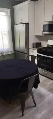 a kitchen with a table and a kitchen with white cabinets at Fill Your Headspace with Tranquility Near NYC in Maplewood
