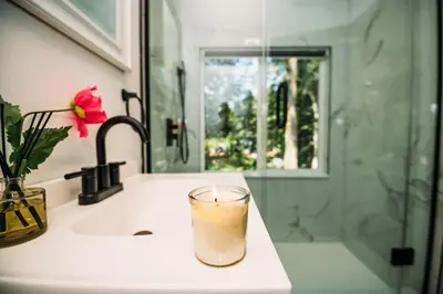 a drink in a glass sitting on a bathroom sink at Creekside Family Dreamland - Hot Tub, Firepit, Arcade in Pocono Summit