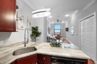 a kitchen with a sink and a living room at Chic High Rise Apt Lux Loft with Pool,Deck & Gym in Philadelphia