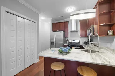 a kitchen with a marble counter top and wooden cabinets at Chic High Rise Apt Lux Loft with Pool,Deck & Gym in Philadelphia