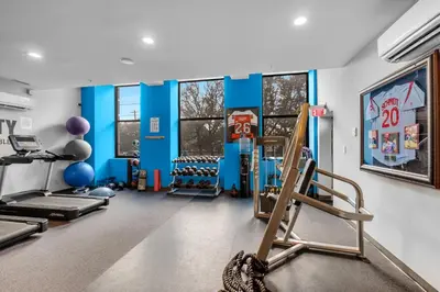 a gym with treadmills and exercise equipment and windows at Chic High Rise Apt Lux Loft with Pool,Deck & Gym in Philadelphia