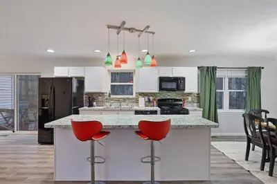 a kitchen with a large island with red bar stools at Spacious Vacation Home Tobyhanna Gym BBQ Boat in Pocono Country Place