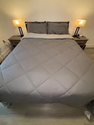 a large bed in a bedroom with two lamps at Nice escape 8 min from EWR in Elizabeth