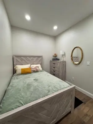 a bedroom with a large bed and a mirror at 3961 Baltimore Penn Campus in Philadelphia