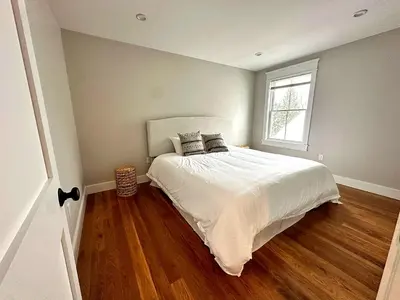 a bedroom with a bed with white sheets and a window at Luxury 3BR with King Beds in Montgomery Village in Montgomery