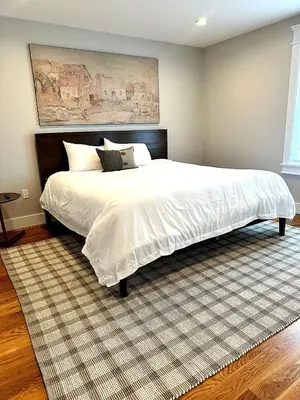 a bedroom with a large white bed with a rug at Luxury 3BR with King Beds in Montgomery Village in Montgomery