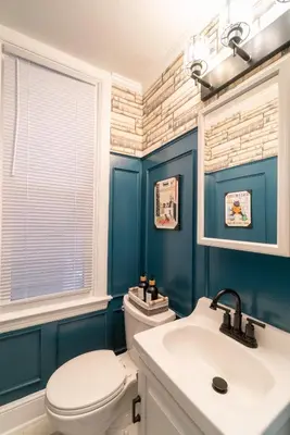 a bathroom with blue walls and a toilet and a sink at Princeton Einstein Boutique Stay in Princeton