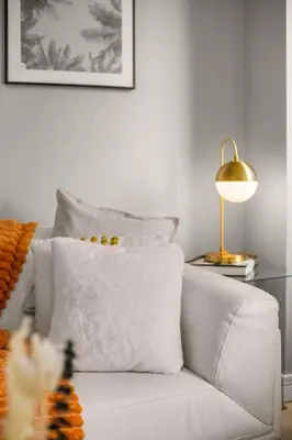 a white couch with a pillow and a lamp at Chic NYC Retreat Beside Broadway in New York