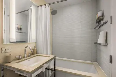 a bathroom with a tub and a sink and a shower at Chic NYC Retreat Beside Broadway in New York