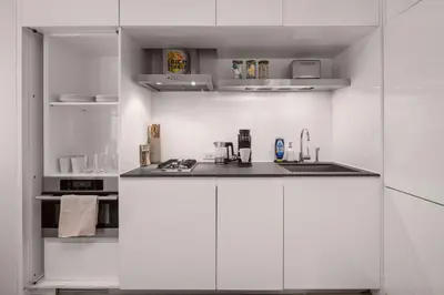 a white kitchen with a sink and a stove at Chic NYC Retreat Beside Broadway in New York