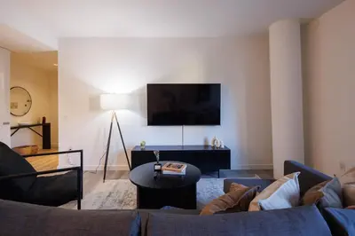 a living room with a couch and a tv at Elegant NYC Haven Walk to Broadway in New York
