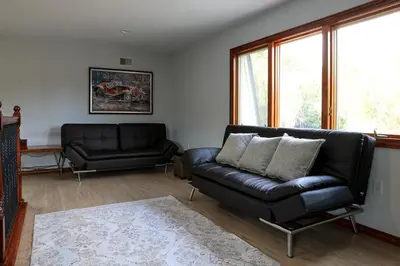 a living room with a black leather couch and window at Bucks County Home Farm Philadelphia Dog Friendly in Warminster