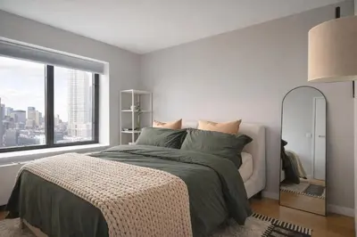 a bedroom with a bed and a large window at Stylish Midtown Escape Near Bryant Park in New York