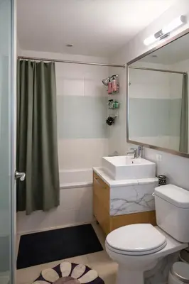 a bathroom with a toilet and a sink and a mirror at Stylish Midtown Escape Near Bryant Park in New York