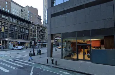 a busy city street with people crossing the street at Stylish Midtown Escape Near Bryant Park in New York