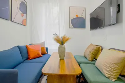 a living room with a blue couch and a table at Classy 2BD Home in Manhattan in New York
