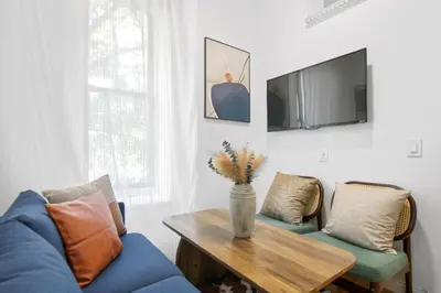 a living room with a blue couch and a table at Classy 2BD Home in Manhattan in New York