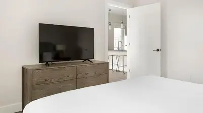 a bedroom with a flat screen tv on a wooden dresser at Landing Spectacular 1BD Clubhouse Gym in Philadelphia