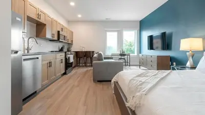 a bedroom with a bed and a kitchen with blue walls at Landing Spectacular 1BD Clubhouse Gym in Philadelphia