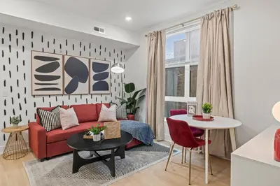 a living room with a red couch and a table at Stylish 1BR Apartment Near Center City & University City in Philadelphia