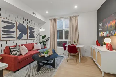 a living room with a red couch and a table at Stylish 1BR Apartment Near Center City & University City in Philadelphia