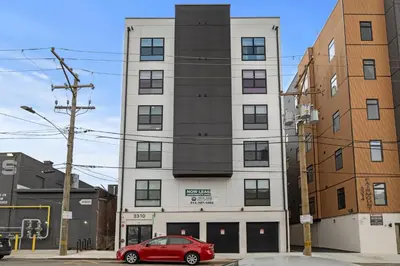 a red car parked in front of a building at Stylish 1BR Apartment Near Center City & University City in Philadelphia