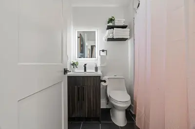 a bathroom with a toilet and a sink and a mirror at Stylish 1BR Apartment Near Center City & University City in Philadelphia