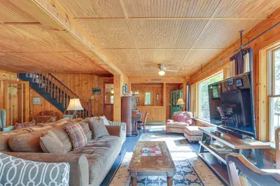 a living room with a couch and a tv at Huge Waterfront Home with Dock on Lake Wallenpaupack in Hawley