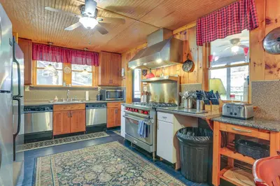 a large kitchen with wooden cabinets and stainless steel appliances at Huge Waterfront Home with Dock on Lake Wallenpaupack in Hawley