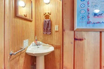 a bathroom with a sink next to a door at Huge Waterfront Home with Dock on Lake Wallenpaupack in Hawley