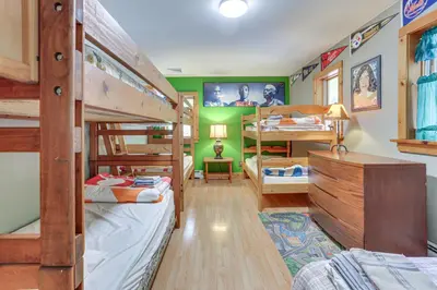 a bedroom with two bunk beds and a room with at Huge Waterfront Home with Dock on Lake Wallenpaupack in Hawley