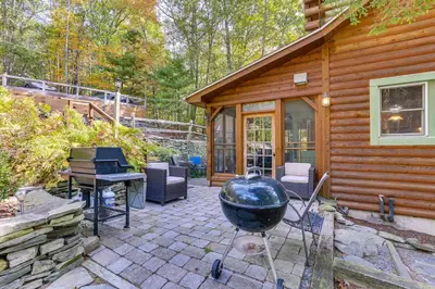 a backyard patio with a grill and a house at Huge Waterfront Home with Dock on Lake Wallenpaupack in Hawley